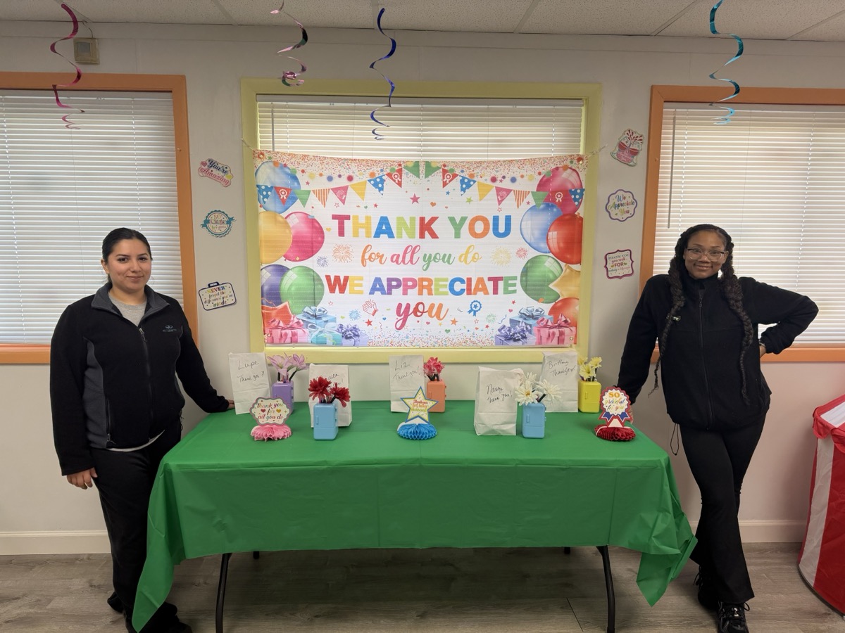 Two staff members beside the gift table on day one